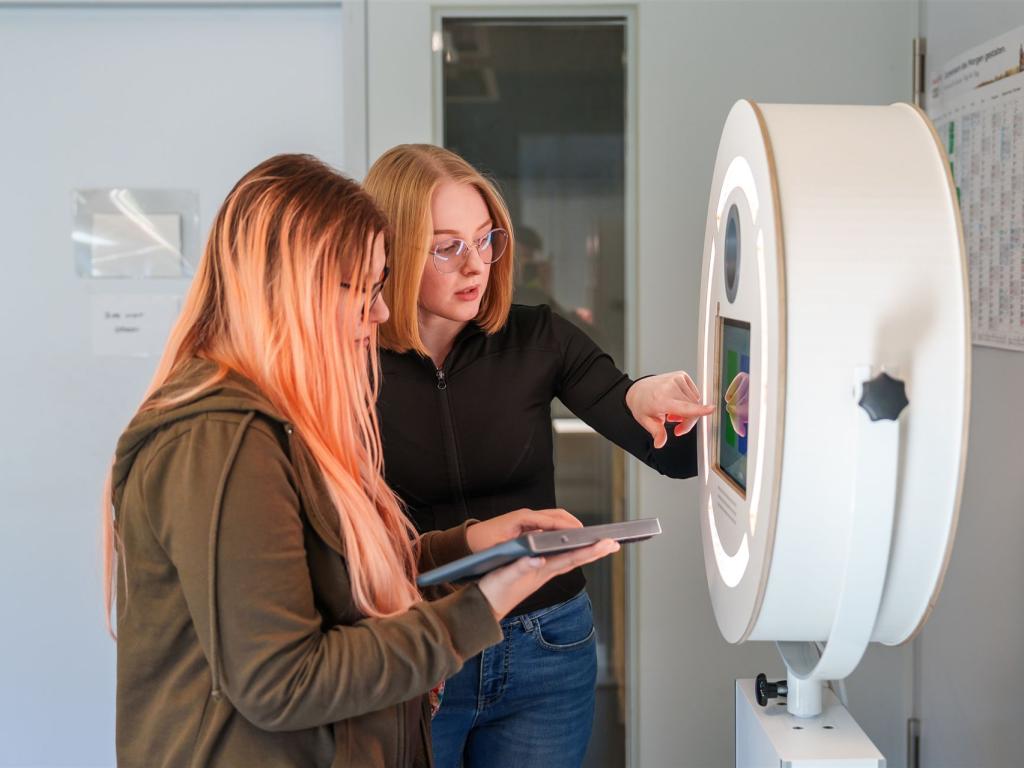 Man sieht zwei Arbeiterinnen vor unserer großen Fotobox.