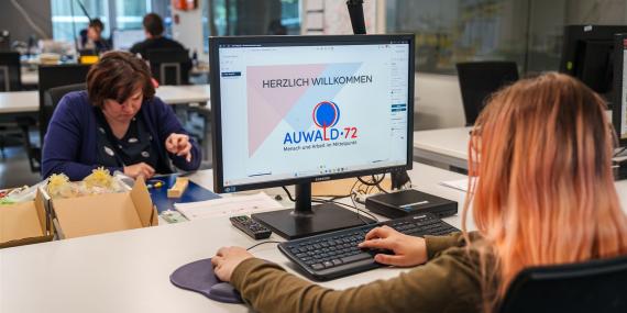 Man sieht eine Mitarbeiterin der Medienschmiede vor dem Computer.