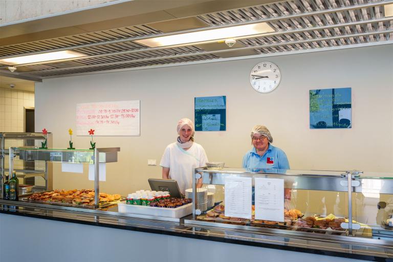 Man sieht zwei Mitarbeiterinnen hinter der Küchentheke.