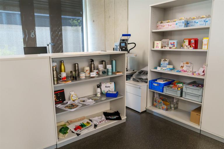 Man sieht ein Regal mit bedruckten Produkten der Medienschmiede.
