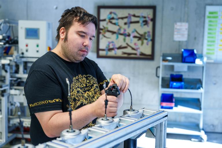 Man sieht einen Mitarbeiter während seiner Arbeit in der Industriemontage.
