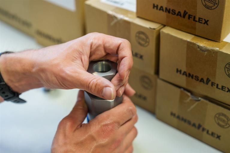 Man sieht eine Nahaufnahme der Arbeit. Teile  werden zusammengestecket und -geschraubt.